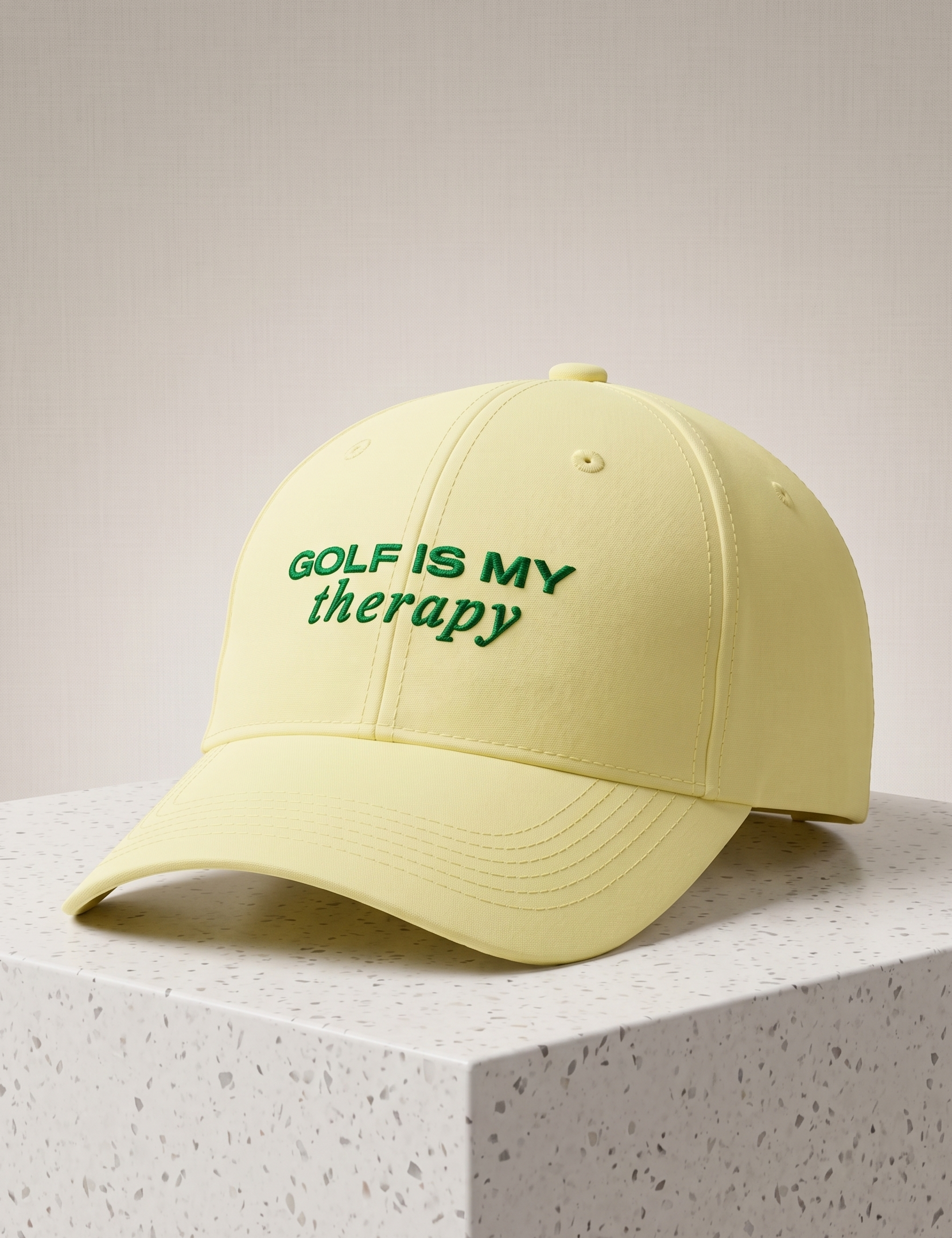 Yellow cap with 'Golf is my therapy' text on a light gray background