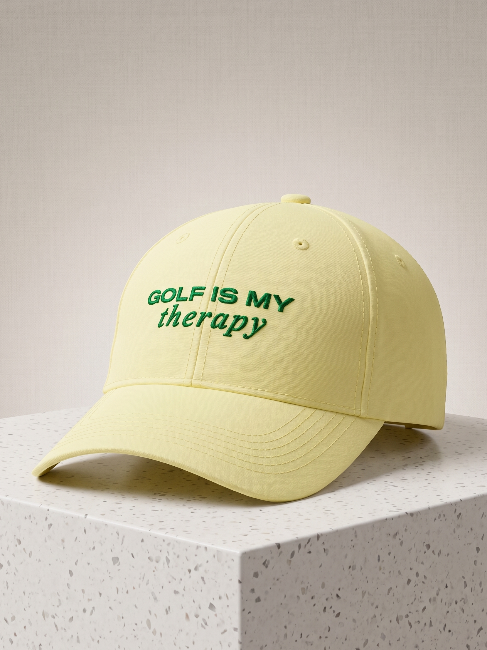 Yellow cap with 'Golf is my therapy' text on a light gray background